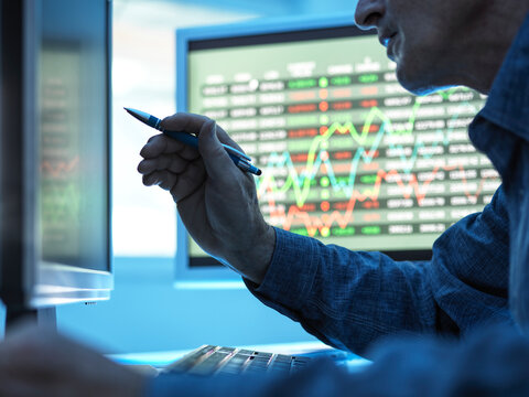 Close up of stock market trader analysing share price data on the screen.