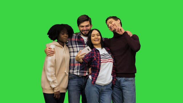 Students posing for a selfie, laughing, making funny faces, showing their tongues on a Green Screen, Chroma Key.