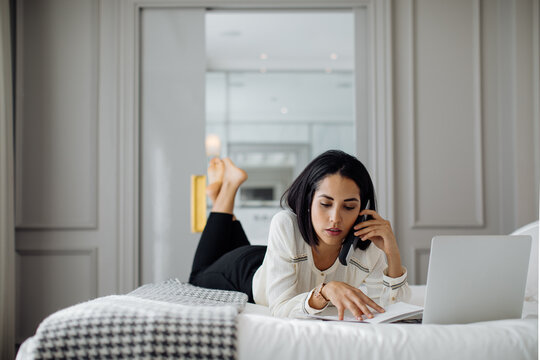 Businesswoman using smartphone and laptop in suite
