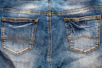 Fototapeta premium Background of old faded jeans. Back pockets of jeans close-up