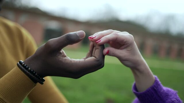 Interracial hands together caress and affection close-up