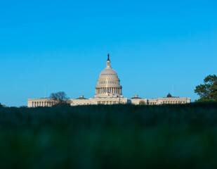 Washington, DC, USA - 27 April 2020: Low-Angle View of the United States Capitol Building with blurred Grass in Foreground - Copy Space