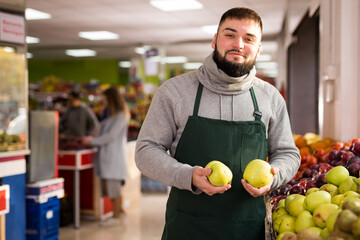 Supermarket employee will lay out ripe apples on the counter. High quality photo