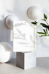 Mock-up poster frames in the interior of geometric shapes. Modern still life scene in neutral colors with an olive branch. Minimal composition with white photo frame and interesting shadows