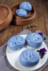 Fototapeta na wymiar Bakpao bunga telang, bakpau or baozi, Chinese steamed bun is tint with blue butterfly pea