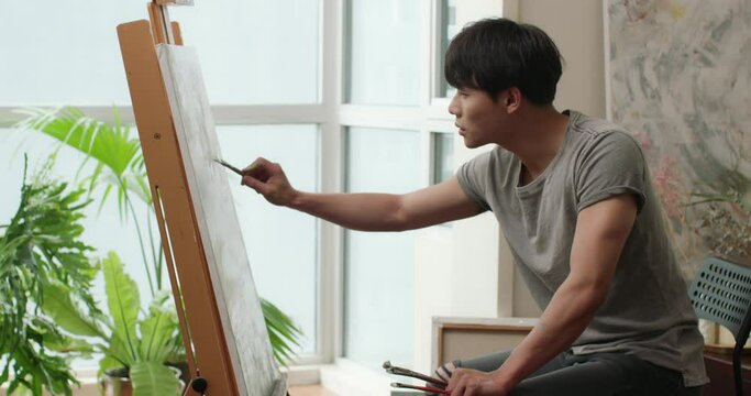 Young Chinese man painting at home,4K