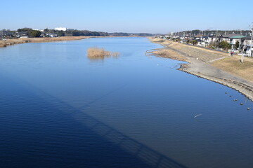 Fototapeta premium 谷田川（やだがわ）／ 茨城県の南部を流れる谷田川は、牛久沼の北側に流入し、南側から流出して小貝川に合流する、利根川水系の一級河川です。東谷田川と呼ばれることもあり、牛久沼から流出した後の谷田川は、八間堀（はっかんぼり）と呼ばれています。写真は茎崎運動公園の周辺です。
