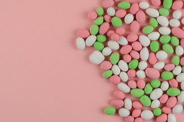 Sweet Dragee scattered on a pink background.