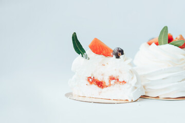 Delicious cakes covered with white and berry cream standing in row against white background