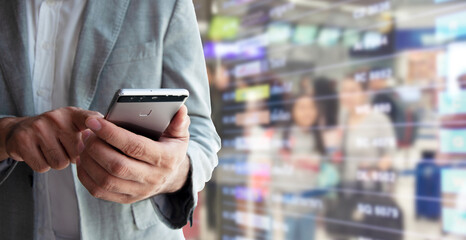 Businessman using smartphone for booking a flight ticket.