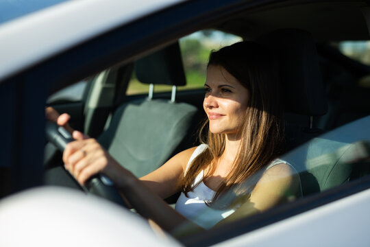 Positive Young Adult Woman Driving Car During Solo Trip, Side View