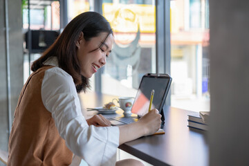 Fototapeta premium Young asian woman thinking about new ideas during working on laptop computer at cafe.