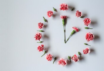 Clock set at 2am made of pink flowers to symbolize the daylight savings 2021 spring forward clock. Flower clock  with copy space. Time concept. Flat lay. Spring concept