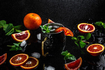 Moscow mule cocktail splashing in copper cup with blood orange, ginger beer, vodka and mint,...