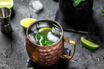 Selbstklebende Fototapeten Icy cold moscow mules with ginger beer and vodka. splashes frozen motion. banner, menu, recipe, place for text © Надія Коваль
