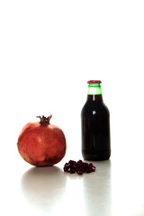 bottle of pomegranate juice, pomegranate and pomegranate seeds isolated on white background