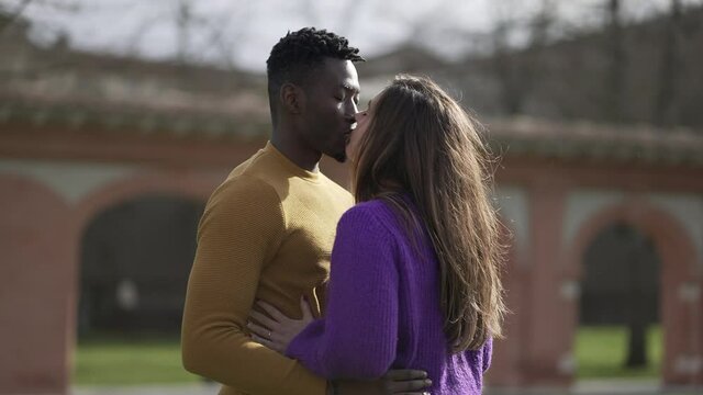 Interracial kiss and hug. Black man with while girlfriend kissing and embrace. love and affection