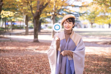 秋の公園でマルを作る女性
