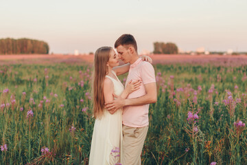 a couple in love walks through a flower meadow. Love and spring blooming. a man embraces a woman