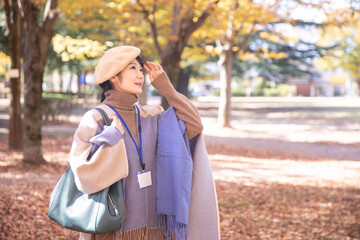秋の公園にいるネームをつけた女性
