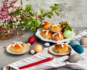 Easter buns and colorful eggs on a table