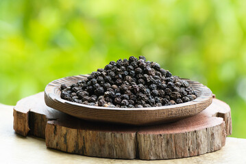 Dried black pepper on nature background.