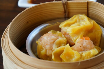 Soft of Focus Dim sum - Chinese steamed pork shrip dumplings in bamboo steamers.