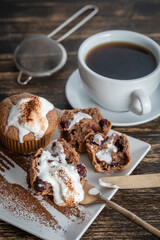 Sweet cherry muffin with ice cream and white cup with tea on a wooden background