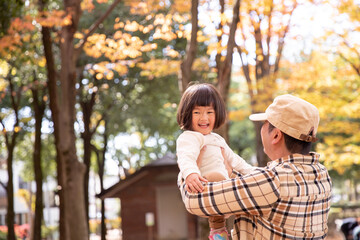 Fototapeta premium 秋の公園で遊ぶ父親と子供 