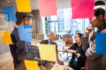 付箋にアイディアを書き出す企画チームの社員たち