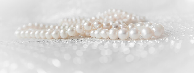 Nature white pearl beads on sparkling background.