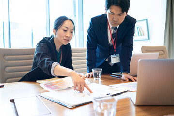 プロジェクトの資料内容に指摘をする女性マネージャー