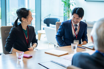 和やかに会話をしながら会議をする社員たち