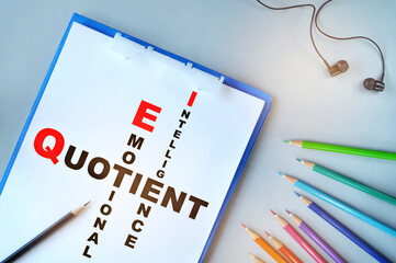 Emotional and intelligence quotient written on desk with coloured pencil on white paper background....