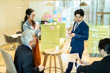 付箋にアイディアを書き出す企画チームの社員たち