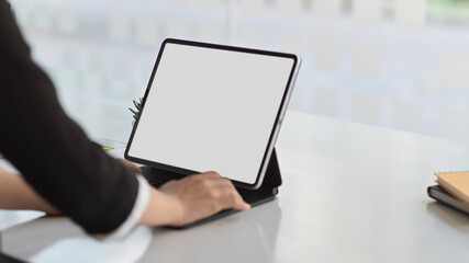 Businesswoman hand working with mock up digital tablet on white desk in office room