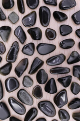 Gold obsidian jewel texture on brown varnished wood background. Sparse mineral pebbles creative.