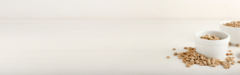 Bowls of coffee beans on light background with space for text