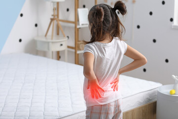 Little girl suffering from back pain in morning because of uncomfortable mattress