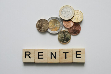 Cubes with word RENTE, coins on white background, no person