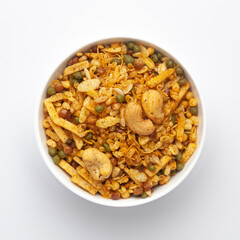 Close up of Rich Spicy Kaju Mixture  Indian namkeen (snacks) on a ceramic white bowl. Top view
