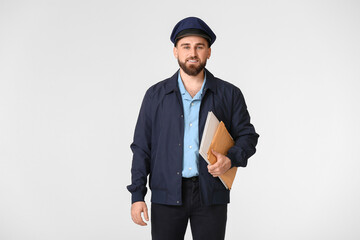 Handsome young postman on light background