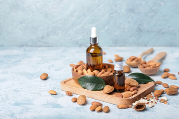 Composition with almond oil and nuts on color background