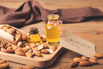 Composition with almond oil and nuts on wooden background