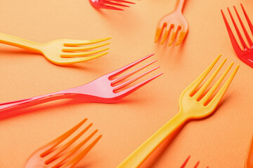 Plastic forks on color background