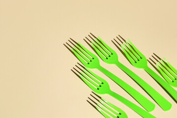 Plastic forks on color background