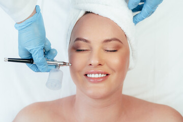 Beautiful woman getting facial skincare treatment in a cosmetic beauty clinic