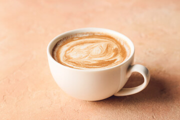 Cup of tasty latte on color background