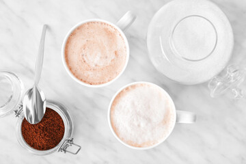 Composition with cups of tasty latte and coffee powder on light background