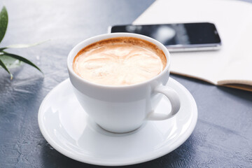 Cup of tasty latte on dark background